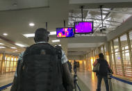 FILE - In this Thursday, Feb. 6, 2020 file photo, passengers from an Ethiopian Airlines flight from Addis Ababa walk past a thermal imaging camera checking for signs of fever as a screening mechanism against signs of infection from the new coronavirus or ebola, upon their arrival at the Jomo Kenyatta International Airport in Nairobi, Kenya. African nations face a difficult choice as infections are rapidly rising: Welcome the international flights that originally brought COVID-19 to the ill-prepared continent, or further hurt their economies. (AP Photo/Ben Curtis, File)