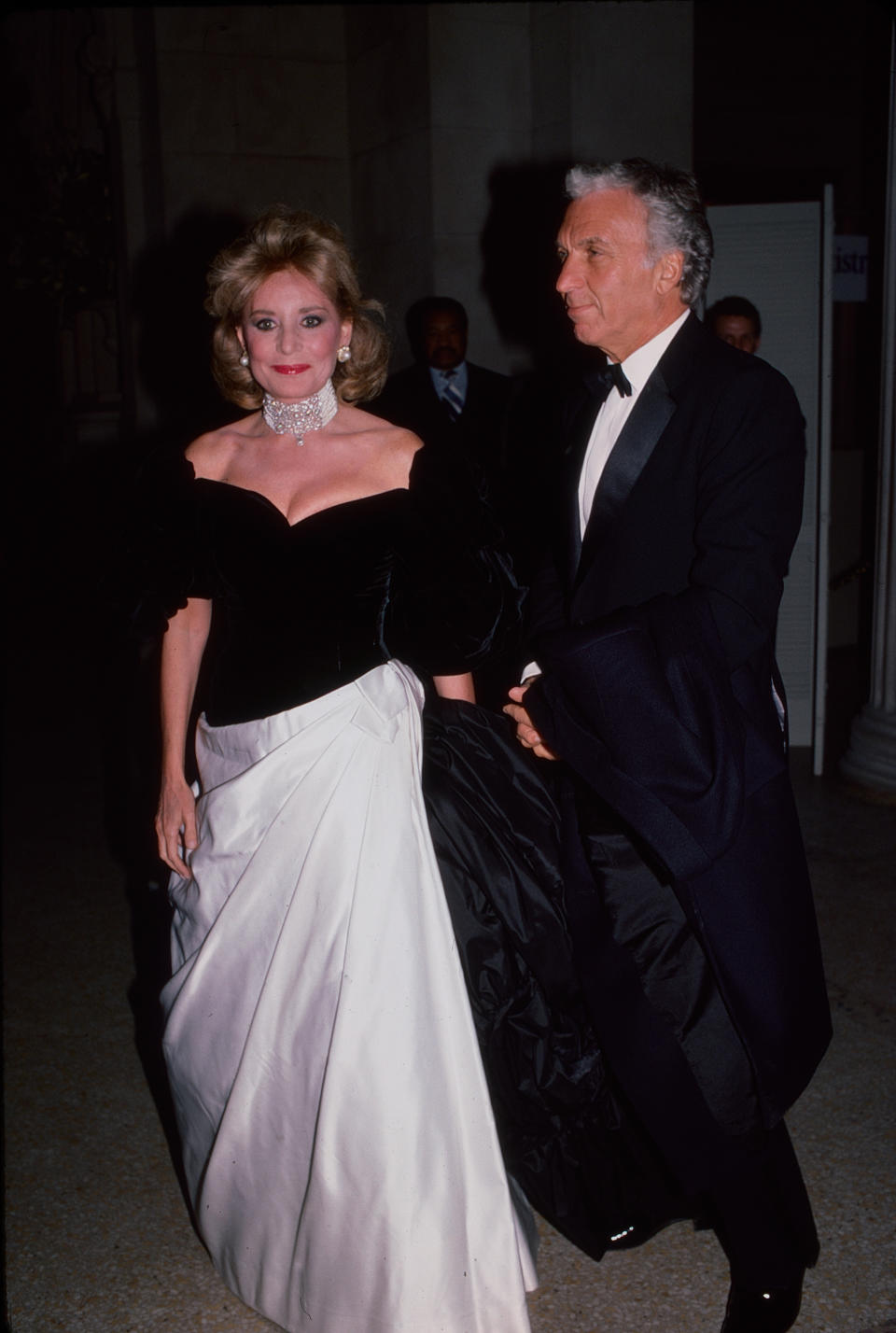 Married American couple, broadcast journalist Barbara Walters (1929 - 2022) and businessman & tv producer Merv Adelson (1929 - 2015), attend the Met Gala at the Metropolitan Museum of Art, New York, New York, December 8, 1986. 