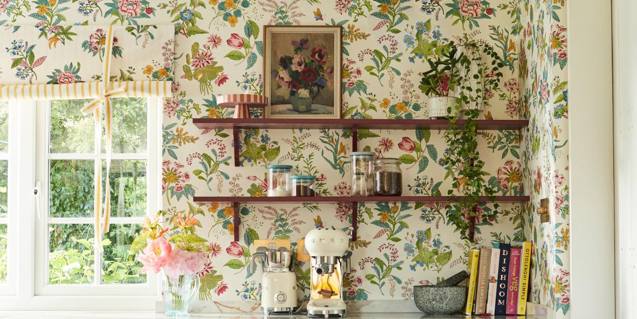 a kitchen with a window and woodland floral wallpaper