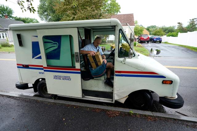 U.S. Postal Service carrier John Graham packs his mail bag after parking a 28-year-old delivery truck, Wednesday, July 14, 2021, in Portland, Maine.