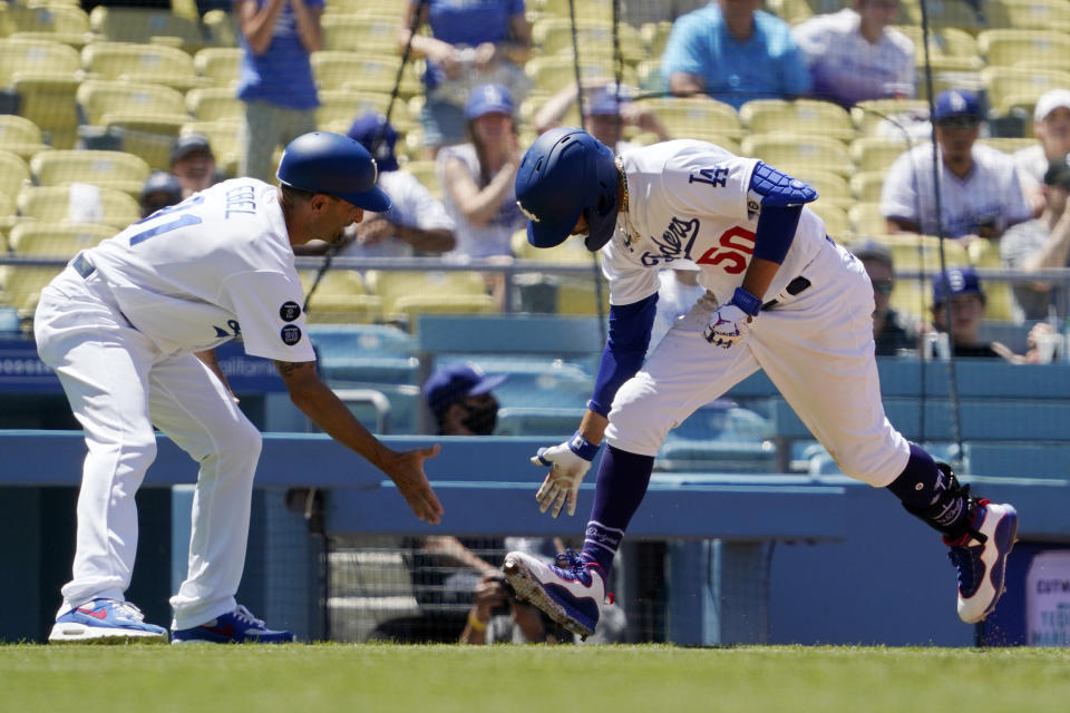 Los Angeles Dodgers' Mookie Betts, right, is congratulated by third base coach Dino Ebel as he rounds third after hitting a solo home run during the third inning of a baseball game against the Texas Rangers Sunday, June 13, 2021, in Los Angeles. (AP Photo/Mark J. Terrill)