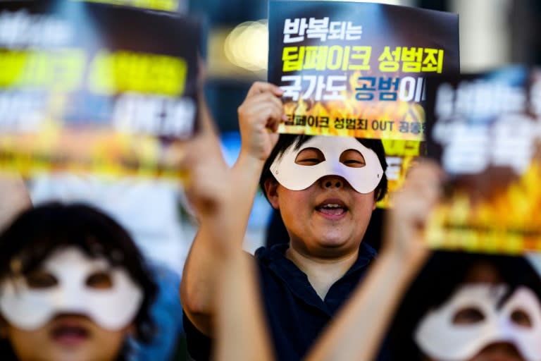 Activists wearing eye masks, hold posters reading ‘Repeated deepfake sex crimes, the state is an accomplice too’ during a protest against deepfake porn in Seoul on August 30, 2024 (Anthony WALLACE)