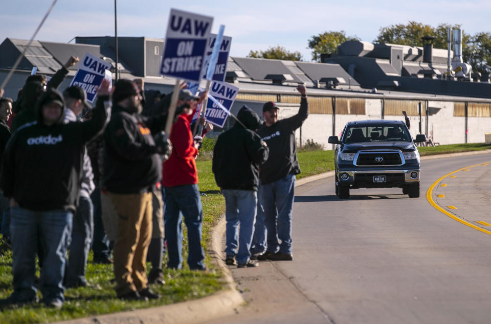 John Deere Drivetrain Operations workers in Waterloo, Iowa, cheer on the picket line as passing cars honk in support as the UAW officially started its strike on Thursday, Oct. 14, 2021. (Chris Zoeller/The Courier via AP)