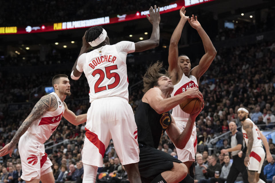 Cleveland Cavaliers' Robin Lopez, second from front right, looks to shoot against the Toronto Raptors defense during second-half NBA basketball game action in Toronto, Monday, Nov. 28, 2022. (Chris Young/The Canadian Press via AP)