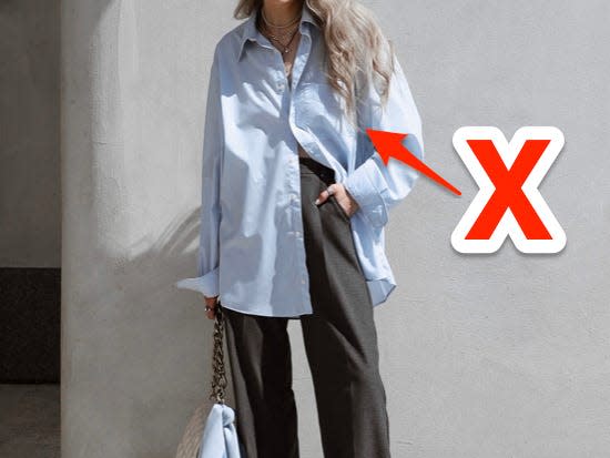 red x and arrow pointing at blue oversized button down someone is wearing with gray slacks