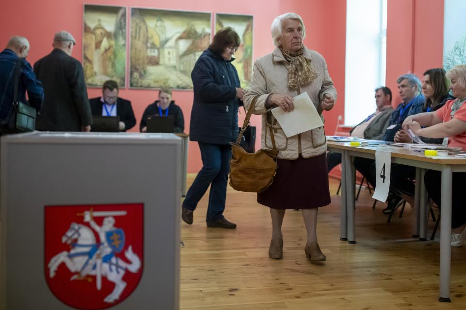 A woman walks to cast their ballots at a polling station during the first round of voting in presidential elections in Vilnius, Lithuania, Sunday, May 12, 2024. (AP Photo/Mindaugas Kulbis)