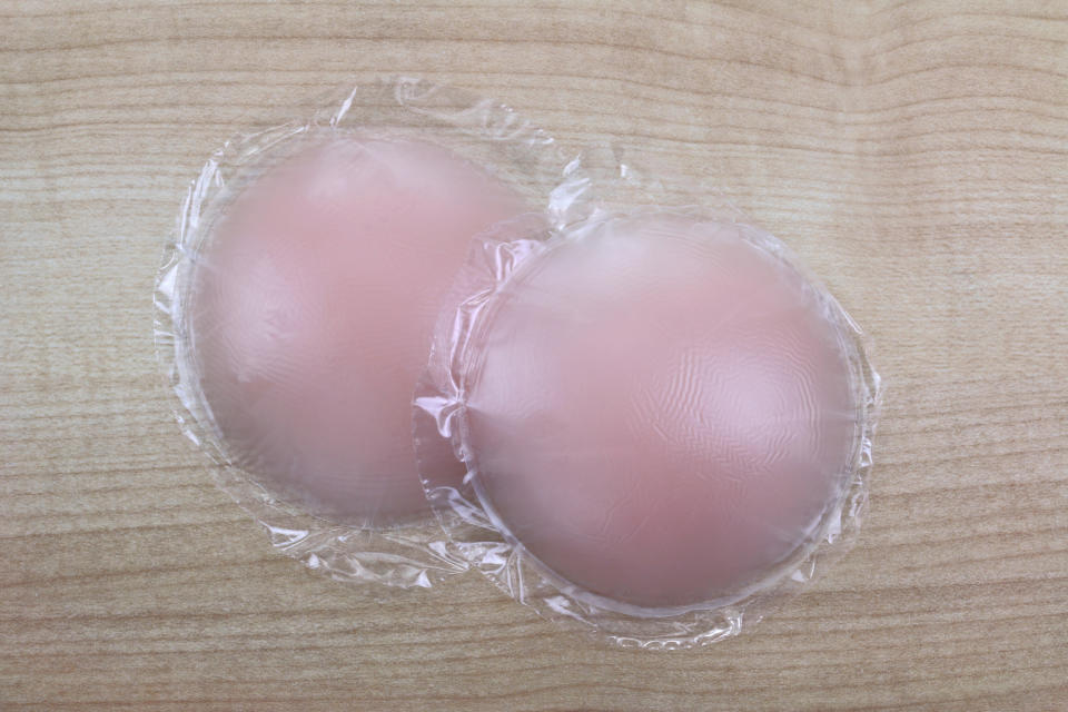 Two silicone adhesive bra inserts on a wooden surface