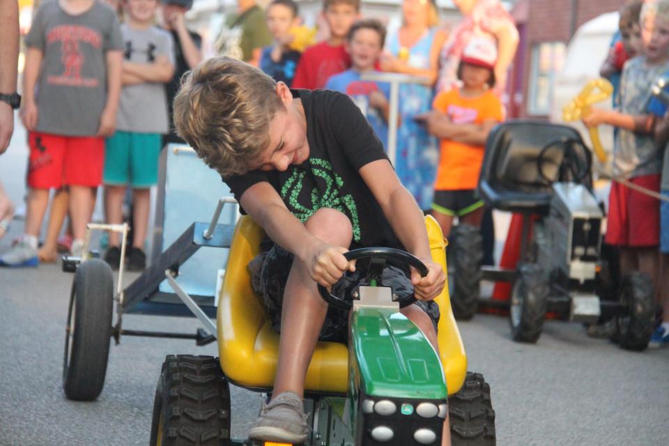 Connor Lawrence, of Dallas Center, concentrates while participating in the Ohana Pedal Power Tractor Pull during the Dallas Center Fall Festival on Friday, Aug. 26, 2022.