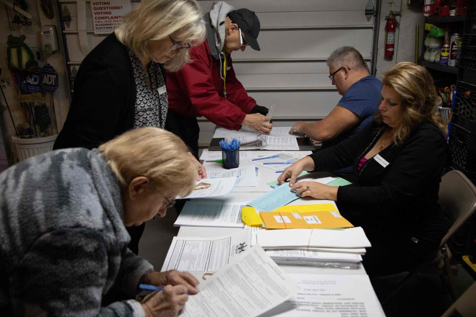 (L-R) Rose English, minority clerk; Evelyn Cain, majority inspector; David Walchesky, judge of elections; James English, minority inspector; and Marlo Miller prepare voting materials in a polling station in Marlo Millers garage for the US midterm election,  in Pittsburgh, Pennsylvania, on November 8, 2022. (Photo by Rebecca DROKE / AFP) (Photo by REBECCA DROKE/AFP via Getty Images) ORIG FILE ID: AFP_32N468B.jpg
