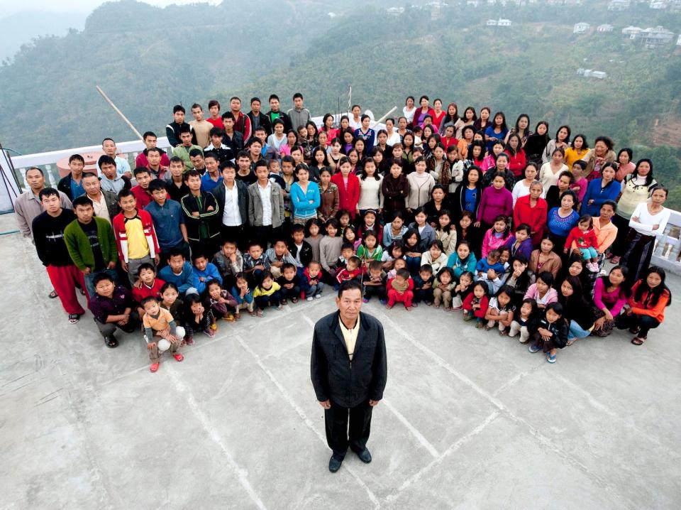 Ziona Chana stands in front of his children, grandchildren, and wives.