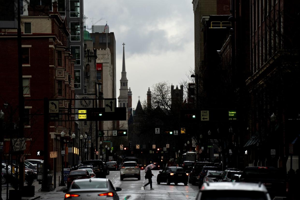 A pedestrian holds an umbrella while walking during a rain storm in Cincinnati on Friday, March 3, 2023. 