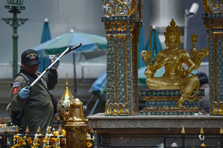 A policeman inspects the cordoned-off site of a bomb blast at the popular Erawan shrine in the heart of Bangkok's tourist and commercial centre, on August 18, 2015