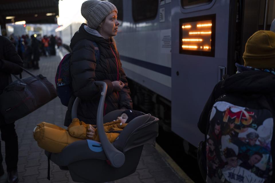 A Ukrainian woman with her baby embarks a train bound to Warsaw, at the Przemysl train station, southeastern Poland, on Friday, March 11, 2022. Thousands of people have been killed and more than 2.3 million have fled the country since Russian troops crossed into Ukraine on Feb. 24. (AP Photo/Petros Giannakouris)