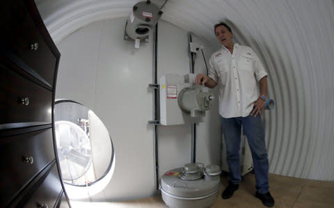 Ron Hubbard, owner of Atlas Survival Shelters, demonstrates the air filtration system of the deluxe 82-foot long 6-person bomb shelter  - Credit: EPA