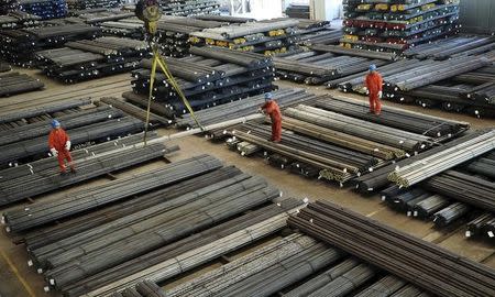 Workers direct a crane lifting newly-made steel bars at a factory of Dongbei Special Steel Group Co., Ltd., in Dalian, Liaoning province, China, October 13, 2015. REUTERS/China Daily