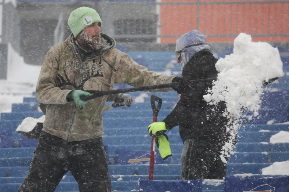 Workers remove snow from Highmark Stadium in Orchard Park, N.Y., Sunday Jan. 14, 2024. A potentially dangerous snowstorm that hit the Buffalo region on Saturday led the NFL to push back the Bills wild-card playoff game against the Pittsburgh Steelers from Sunday to Monday. New York Gov. Kathy Hochul and the NFL cited public safety concerns for the postponement, with up to 2 feet of snow projected to fall on the region over a 24- plus hour period. (AP Photo/ Jeffrey T. Barnes)