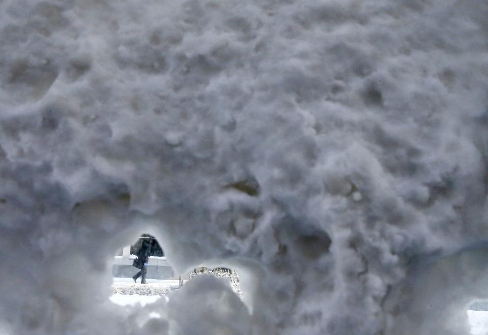 A person walks past a snow covered bus shelter in downtown Chicago, Illinois January 6, 2014. A blast of Arctic air gripped the mid-section of the United States on Monday, bringing the coldest temperatures in two decades. Meteorologists said temperatures were dangerously cold and life-threatening in some places, with 0 degrees Fahrenheit (minus 18 Celsius) recorded in Chicago, St. Louis and Indianapolis. The chill was set to bear down on eastern and southern states as the day wore on. REUTERS/Jim Young (UNITED STATES - Tags: ENVIRONMENT SOCIETY TPX IMAGES OF THE DAY)