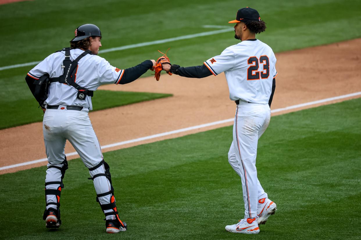 Oklahoma State pitcher Juaron Watts-Brown (23) and Oklahoma State catcher Ian Daugherty (8) fist bump during a college baseball game between the Oklahoma State Cowboys (OSU) and the Loyola Marymount University Lions (LMU) at O’Brate Stadium in Stillwater, Okla., on Saturday, Feb. 25, 2023.