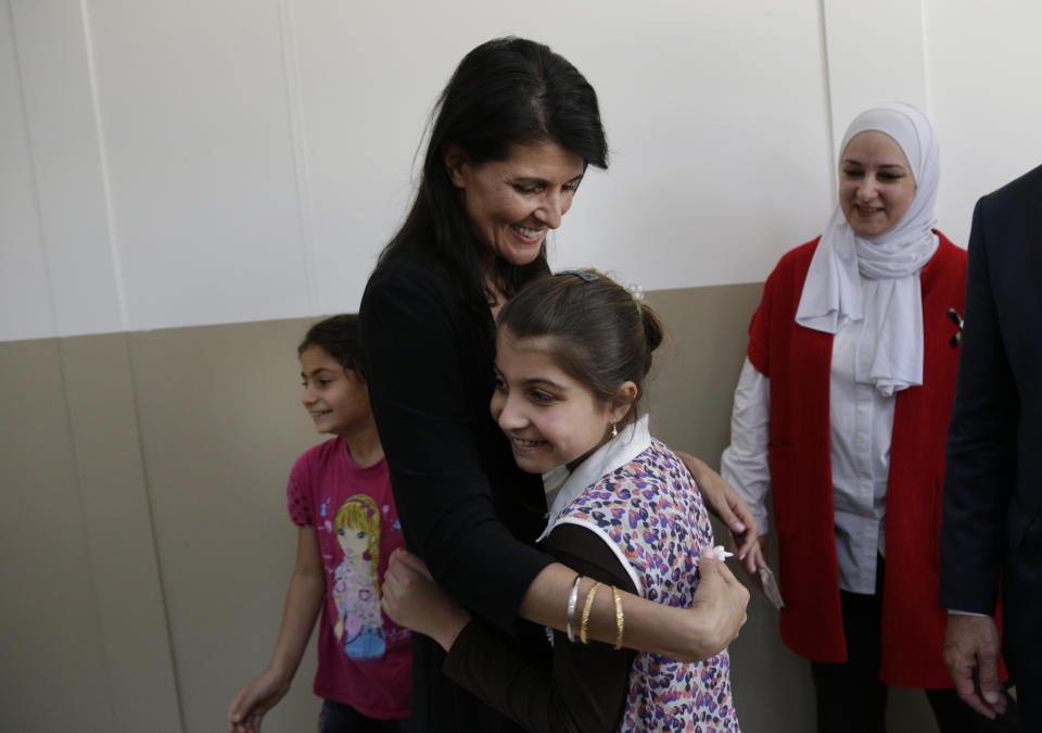 FILE - U.S. Ambassador to the United Nations Nikki Haley, hugs a Syrian refugee child at the Sakirpasa Umran school, funded by the US government, following its opening ceremony in Adana, southern Turkey, May 24, 2017. (AP Photo/Burhan Ozbilici, Pool, File)