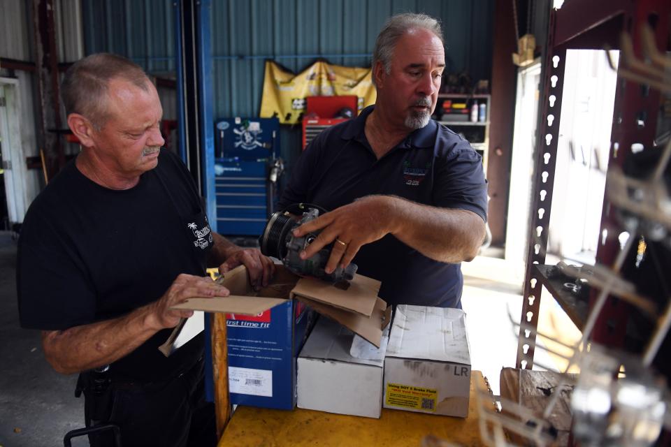 Bobby Ford (right) talks with longtime employee Dickey Millard in the service bay of Ford's shop, Bobby's Auto Service Center, on Wednesday, Sept. 1, 2021, in Vero Beach. Both Ford and his twin brother, Billy, became sick with coronavirus. But Ford was vaccinated while his brother was not. Billy Ford died Aug. 14, leaving behind a wife, three children, his mother and three brothers.