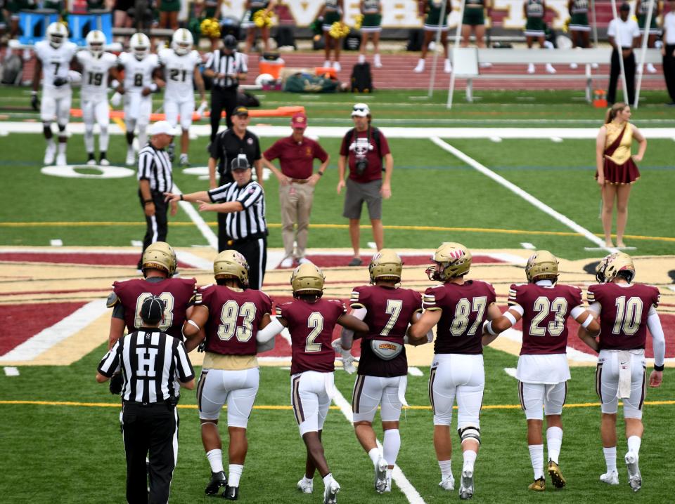 Walsh University players walk on field for the coin flip before the football team's first game on campus at Larry Staudt Field.