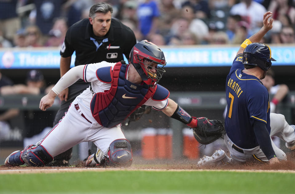 Milwaukee Brewers' Victor Caratini (7) scores as Minnesota Twins catcher Ryan Jeffers (27) tries to tag him out during the third inning of a baseball game Tuesday, June 13, 2023, in Minneapolis. (Reée Jones Schneider/Star Tribune via AP)