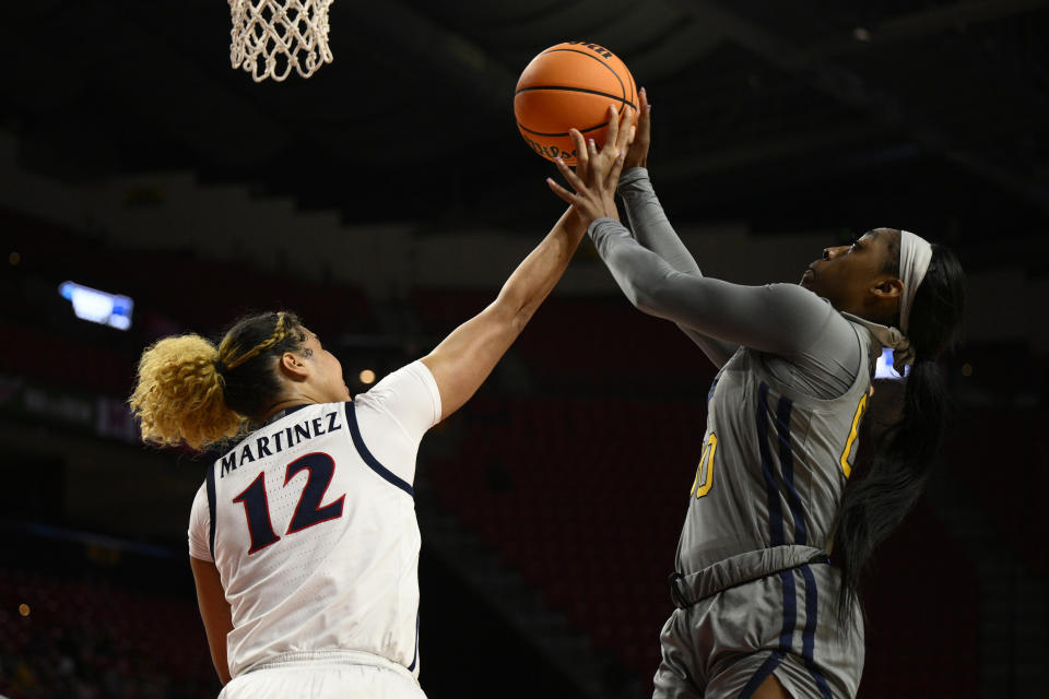 West Virginia guard Jayla Hemingway, right, and Arizona forward Esmery Martinez (12) battle for the ball in the first half of a first-round college basketball game in the NCAA Tournament, Friday, March 17, 2023, in College Park, Md. (AP Photo/Nick Wass)