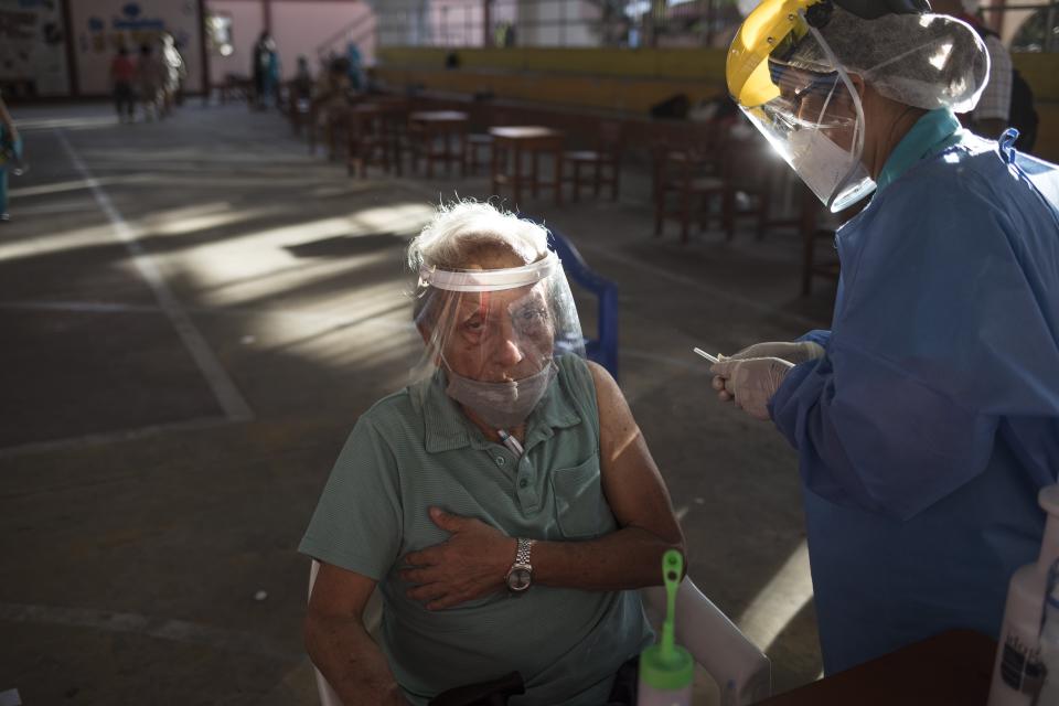 Una enfermera se prepara para inocular a Jorge Pérez Padilla con una dosis de la vacuna Pfizer contra COVID-19 en Iquitos, Perú, el jueves 18 de marzo de 2021. A pesar del escándalo que sacudió al gobierno en la capital peruana cuando más de 480 funcionarios del gobierno se aprovecharon de sus posiciones privilegiadas para recibir en secreto vacunas tempranas antes de los trabajadores de la salud que luchan contra la nueva pandemia de coronavirus, 66 personas con conexiones en Iquitos saltaron la cola esta semana para vacunarse. (AP Foto/Rodrigo Abd)