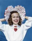 <p>Actress Terry Moore rocks a frilly heart-shaped bonnet and a funky pendant. </p>