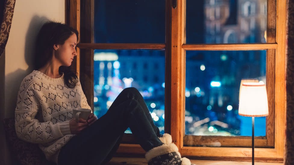 Una mujer sentada frente a su ventana