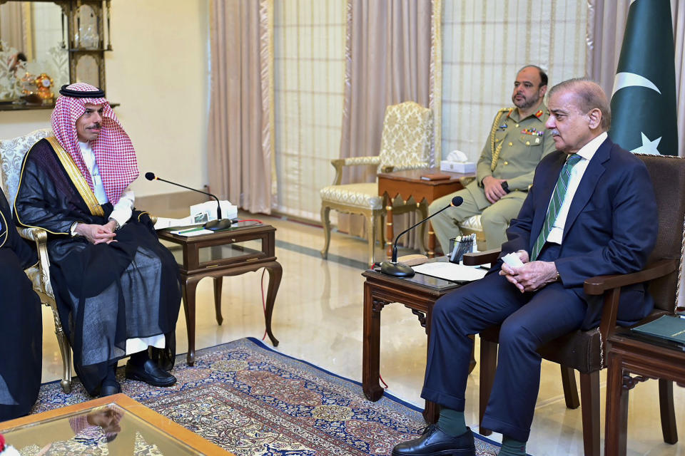 In this photo released by Prime Minister Office, visiting Saudi Foreign Minister Prince Faisal bin Farhan, left, listens to Pakistan's Prime Minister Shehbaz Sharif during a meeting in Islamabad, Pakistan, Tuesday, April 16, 2024. Saudi Arabia's foreign minister led a high-level delegation on a two-day visit to Pakistan, which is seeking help in overcoming one of its worst economic crises. (Prime Minister Office via AP)