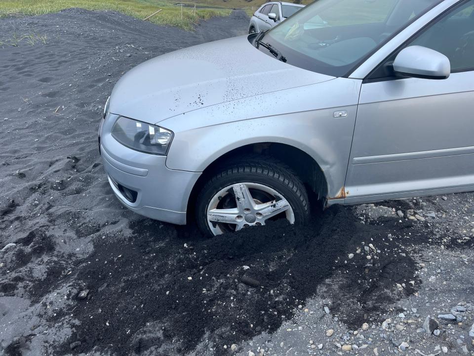 A car stuck in black sand in Iceland.