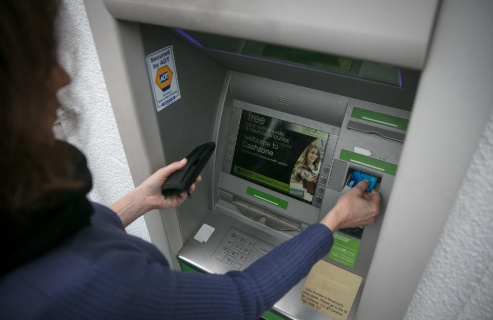 In this photo illustration a woman uses a cashpoint ATM on November 3, 2017 in Bristol, England. (Photo by Matt Cardy/Getty Images)