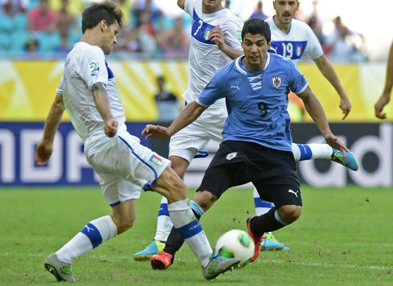 Uruguay's forward Luis Suarez (L) marks Italy's defender Christian Maggio during their FIFA Confederations Cup Brazil 2013 third-place football match, at the Fonte Nova Arena in Salvador, on June 30, 2013. Italy won 3-2 on penalties