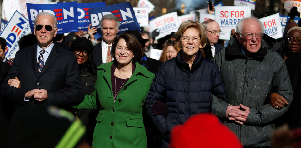 Seven of the Democratic U.S. Presidential candidates including former U.S. Vice President Joe Biden, Sen. Amy Klobuchar, Sen. Elizabeth Warren and Sen. Bernie Sanders, walk arm-in-arm with local African-American leaders during the Martin Luther King Jr. (MLK) Day Parade in Columbia, South Carolina on January 20, 2020.  (Randall Hill/Reuters)