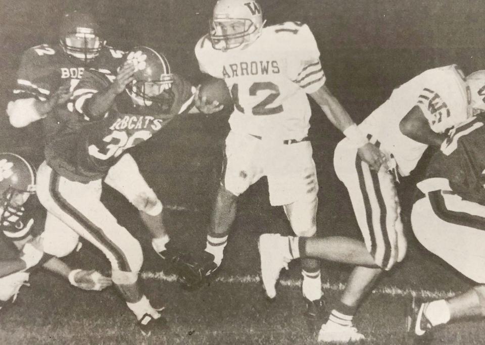 Watertown High School quarterback Heath Rylance (12) finds a hole to run through with Brookings' Steve Wenande (38) in hot pursuit during their Eastern South Dakota Conference football game in the fall of 1989.
