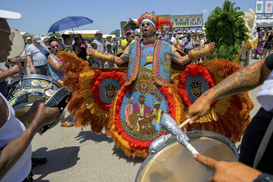 Big Chief Dow "Croco-Dow" Edwards of the Timbuktu Warriors dances to drums during a procession through the Fair Grounds at the New Orleans Jazz and Heritage Festival in New Orleans, Thursday, April 25, 2024. The Black Masking Indians culture is unique to New Orleans beginning in the 1800s but African-Americans have been dancing with drums and feathers for hundreds of years in Louisiana. (AP Photo/Matthew Hinton)