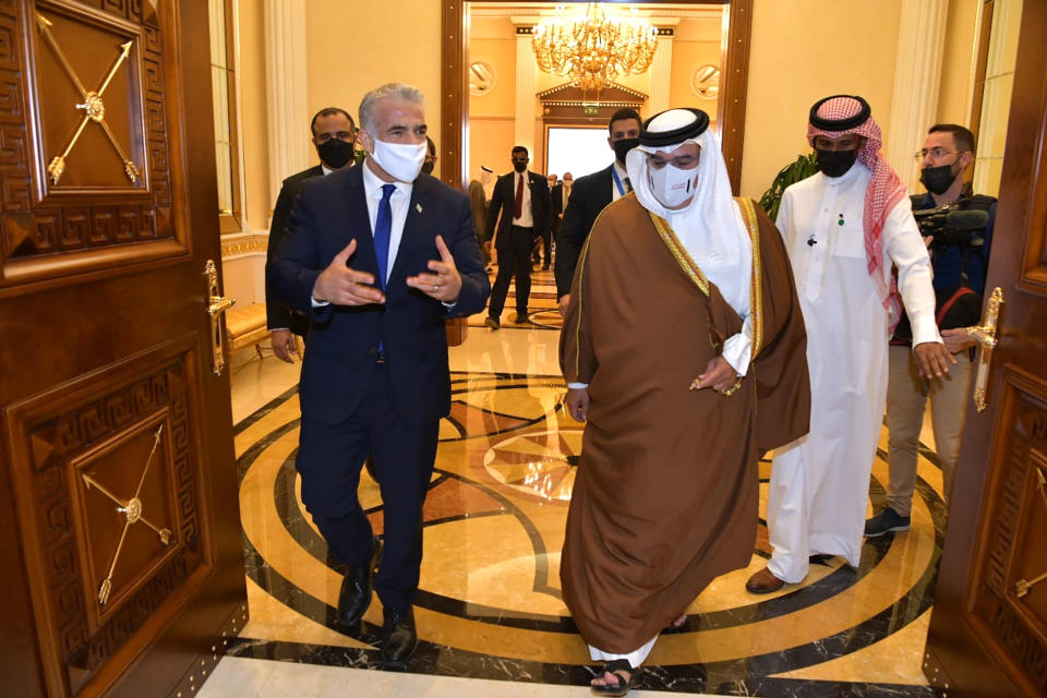 In this photo provided by the Israeli Government Press Office, Israel's Foreign Minister Yair Lapid, left, walks with Bahrain's Crown Prince Salman bin Hamad Al Khalifa, during the first high-level visit to the small Gulf state by a senior Israeli official since the signing of a landmark agreement to establish diplomatic ties between the two countries last year, in Manama, Bahrain, Thursday, Sept. 30, 2021. Lapid will inaugurate Israel’s embassy. (Shlomi Amshalem/GPO via AP)