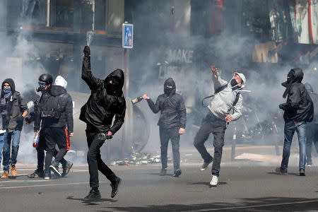 Hooded youths throw bottles during clashes at a demonstration to protest the results of the first round of the presidential election in Paris, France, April 27, 2017. REUTERS/Gonzalo Fuentes