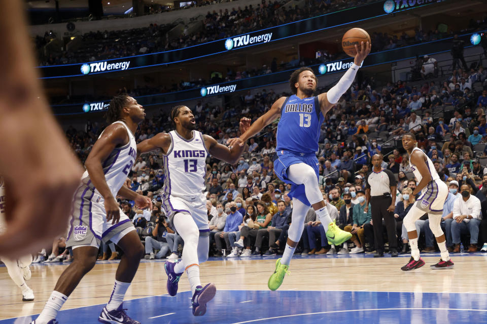 Dallas Mavericks guard Jalen Brunson (13) goes for a layup in front of Sacramento Kings center Tristan Thompson (13) and guard Buddy Hield (24) during the first half of an NBA basketball game in Dallas, Sunday, Oct. 31, 2021. (AP Photo/Michael Ainsworth)