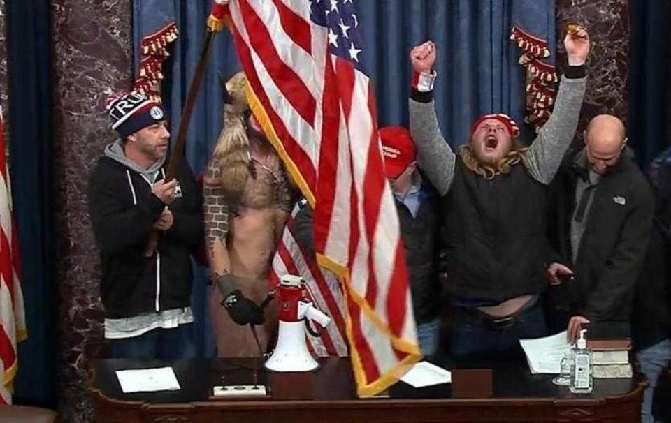 Tommy Frederick Allan of Rocklin, at left, is seen holding a U.S. flag in a photo from January 6, 2021, that was including in a federal complaint for his suspected role in the U.S. Capitol riot. He faces sentencing in December.