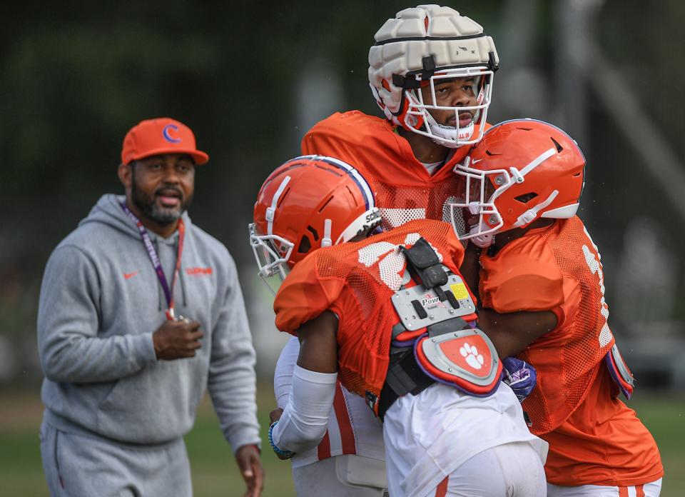 Clemson special teams coordinator Mike Reed watches cornerback Malcolm Greene (21) and safety Kylon Griffin (18) lift linebacker Jeremiah Trotter Jr. (54) during practice in Clemson on Aug. 12, 2022.