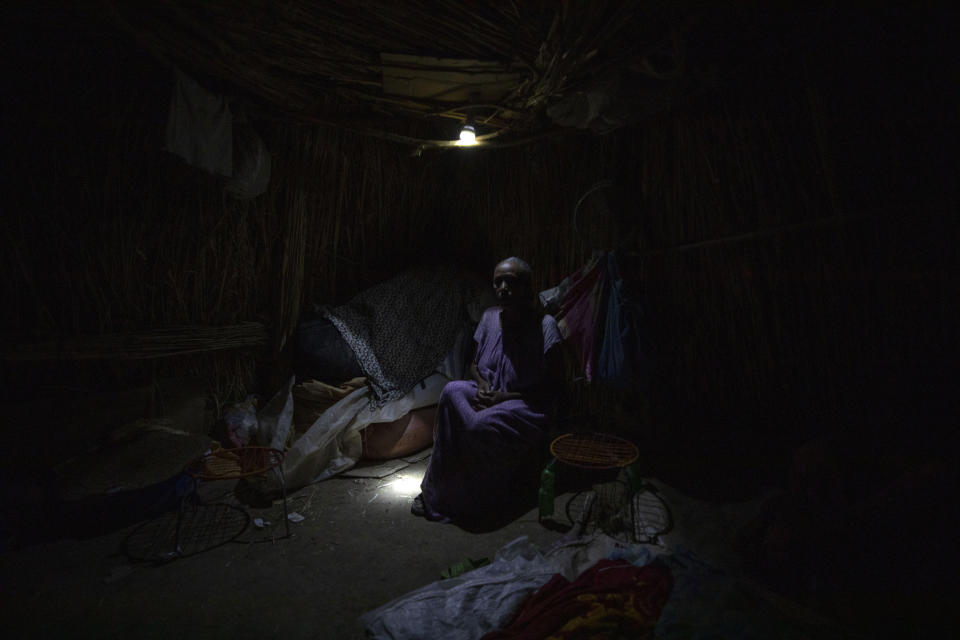 Tigrayan refugee Belaynesh Beyene, 58, who fled the conflict in the Ethiopia's Tigray, sits in her shelter in Hamdayet, eastern Sudan, near the border with Ethiopia, on March 13, 2021. Beyene said she saw 24 bodies in Dansha. "They accidentally killed an ethnic Oromo in a Tigrayan household," she said. "When they realized their 'mistake,' they came and buried him." (AP Photo/Nariman El-Mofty)