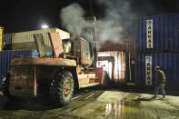 In this photo released by the Syrian official news agency SANA, shows a bulldozer moving burned containers from the scene of a missile attack, at the seaport of the coastal city of Latakia, Syria, Tuesday, Dec. 7, 2021. Syria’s military said Israeli warplanes fired the missiles causing fire without inflicting any human losses. Syria’s state media quoted an unnamed military official as saying that several missiles struck the containers area in the port early on Tuesday, setting some of them on fire. (SANA via AP)