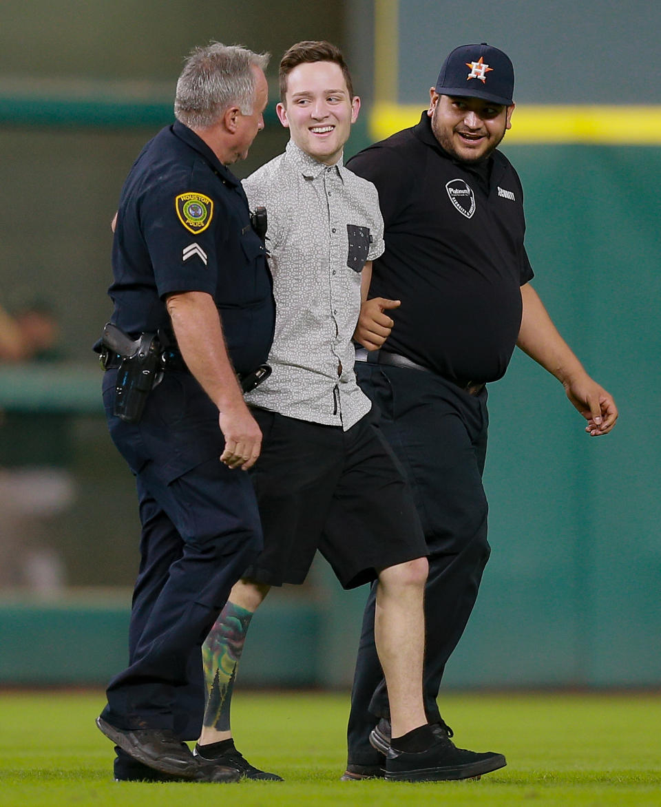 Houston Police and stadium security escort a fan off the field after he ran onto the field in he ninth inning during a game between the Oakland Athletics and Houston Astros at Minute Maid Park on August 30, 2016 in Houston, Texas. (Photo by Bob Levey/Getty Images)