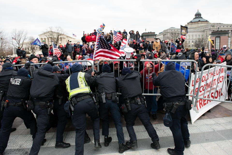 U.S. Capitol Police scuffle with demonstrators after they broke through security fencing outside of the U.S. Capitol building in Washington, D.C., on Wednesday, January 6, 2021. / Credit: Graeme Sloan/Bloomberg via Getty Images
