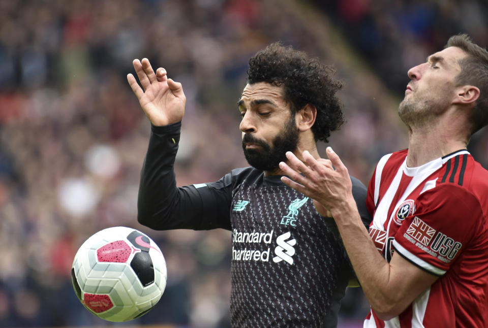 Liverpool's Mohamed Salah, left, duels for the ball with Sheffield United's Enda Stevens during the English Premier League soccer match between Sheffield United and Liverpool at Bramall Lane in Sheffield, England, Saturday, Sept. 28, 2019. (AP Photo/Rui Vieira)