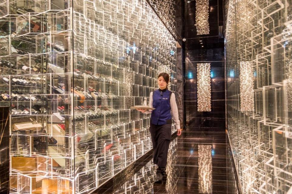 餐廳打造了透明壓克力光牆廊道，為頂級鍋物店帶來前衛炫目感。