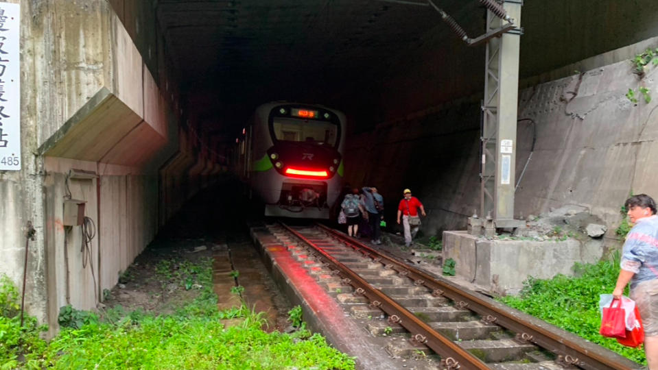 台鐵自強號第229次北上列車今（6/21）清水隧道受到土石流衝擊出軌，乘客下車步行搭接駁車。讀者提供