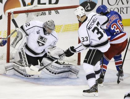 Kings goalie Jonathan Quick blocks a shot by Rangers winger Mats Zuccarello as Willie Mitchell helps defend during Game 3 of the Stanley Cup final Monday in New York. (AP)